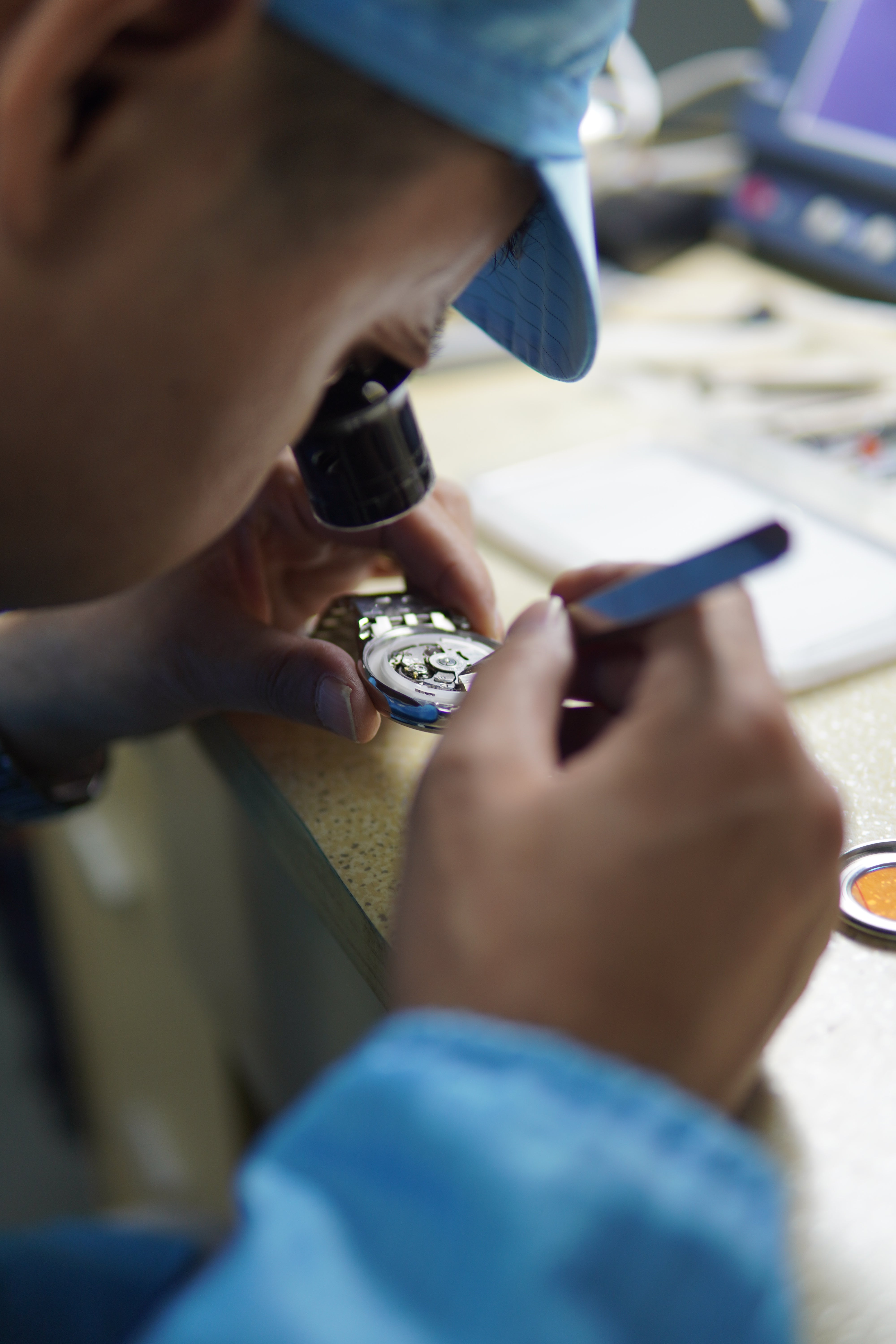 Watchmaker assembling a Daniel Gorman timepiece, showcasing precision craftsmanship and attention to detail in the production process.